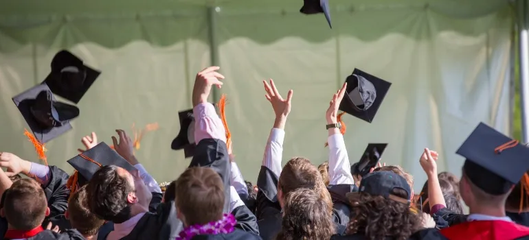 students throwing their graduation caps