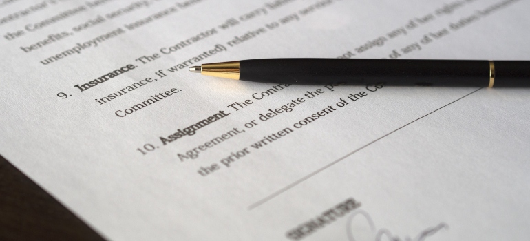 a pen and paper that needs signing as a part of a guide to international shipping