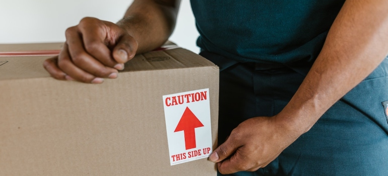 A mover packing a box as WA businesses need commercial moving services