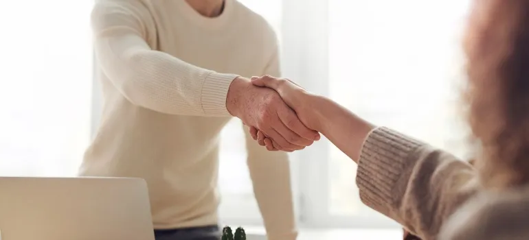 A man and a woman shaking hands in an office