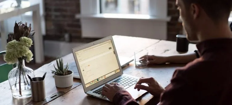 Man using his laptop to research ways to reduce carbon footprint during Seattle relocation
