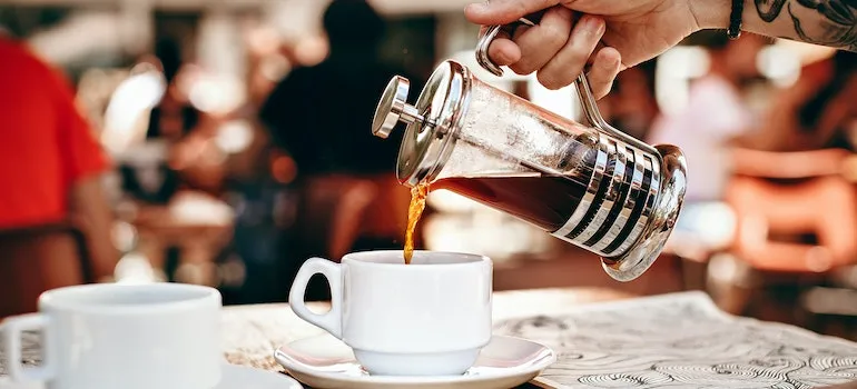 Person Pouring Coffee into White Ceramic Cup