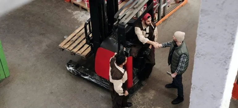 Men gathered around heavy equipment shaking hands