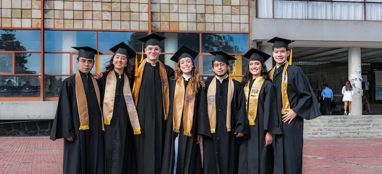 A group of graduates in their robes in front on Washington University that offers many education resources for new residents in Seattle