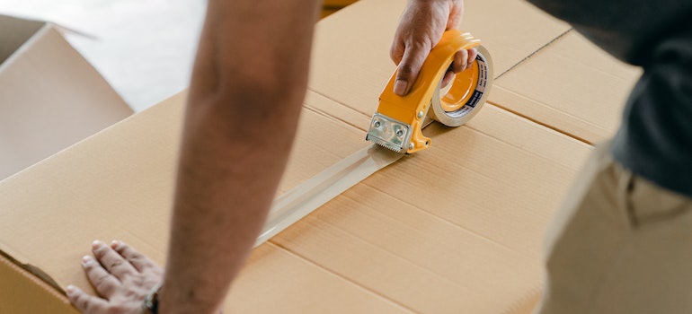A man packing a box with scotch tape