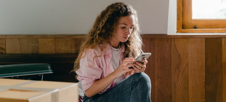 Young woman using smartphone to call movers North Bend WA