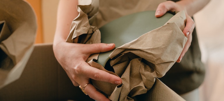 A woman with packing paper and belongings