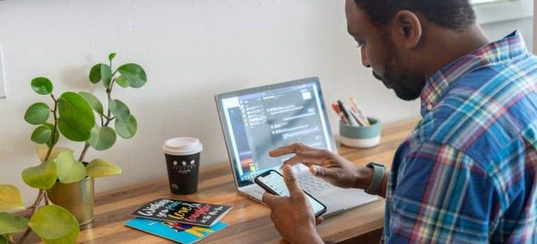 Man using his smart phone while sitting at a desk