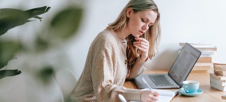 Woman taking notes of things to know about moving company reviews