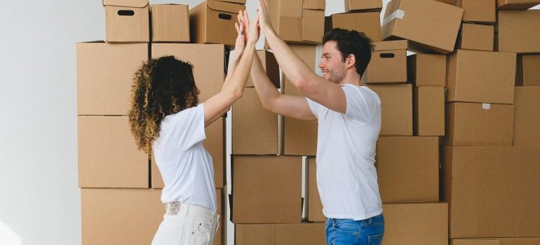 A couple high fiving each other after finding out all the things to know about moving company reviews