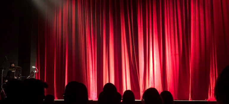 A red curtain in front of People at Theater