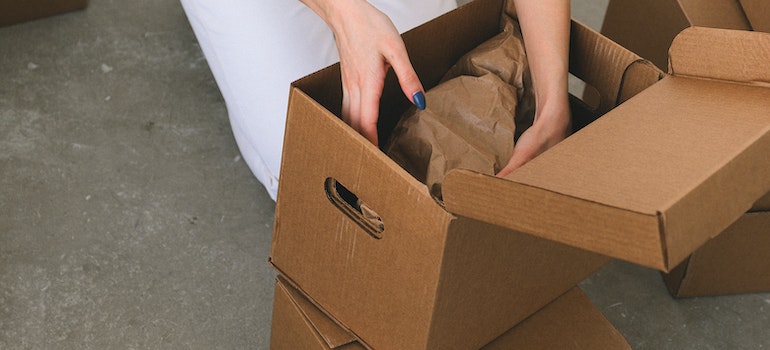 A woman packing a cardboard box to store holiday decorations