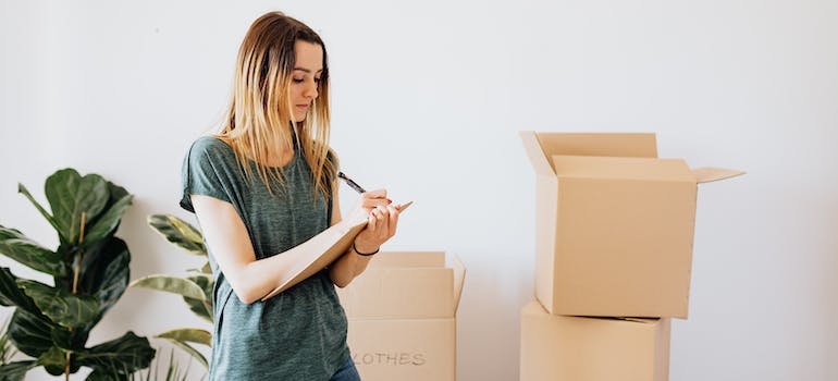 A woman writing down notes while packing for hybrid moves in Seattle