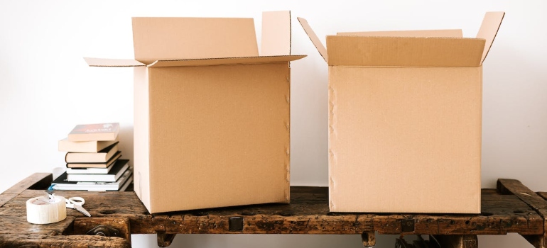 Carton boxes, packing supplies, and stacked books on a table