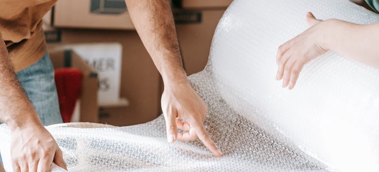 Couple Holding A Roll Of Bubble Wrap