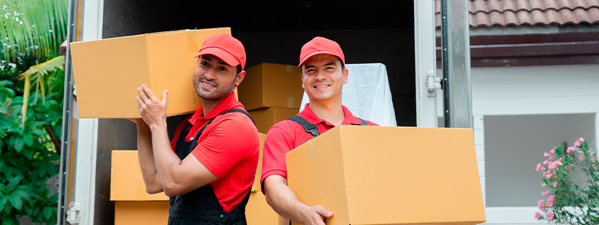 Two men in red attire are seen carrying boxes as they relocate from Seattle to Bellevue.
